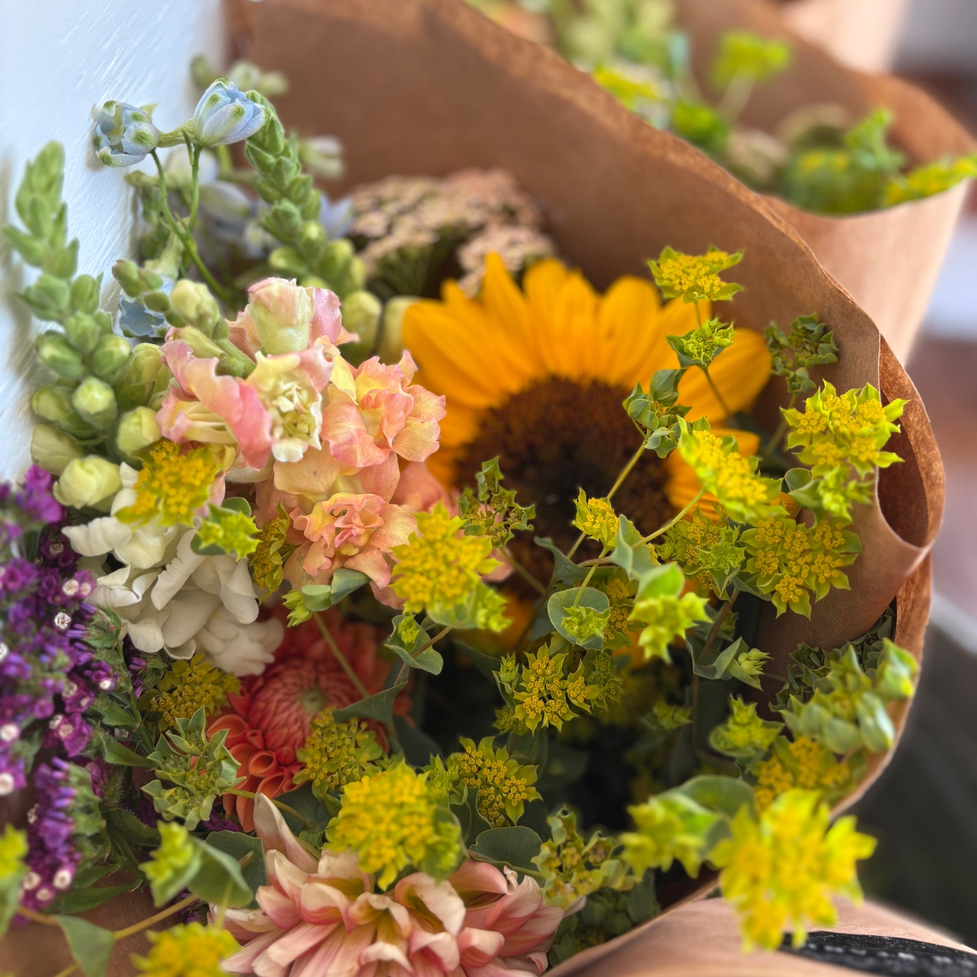 Bouquets of flowers wrapped in brown paper on a white background